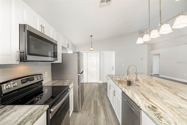 kitchen featuring sink, light hardwood / wood-style flooring, decorative backsplash, vaulted ceiling, and stainless steel appliances