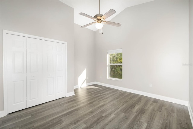 unfurnished bedroom featuring ceiling fan, high vaulted ceiling, hardwood / wood-style flooring, and a closet