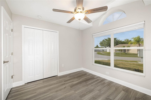 unfurnished bedroom featuring ceiling fan, a closet, and dark hardwood / wood-style flooring