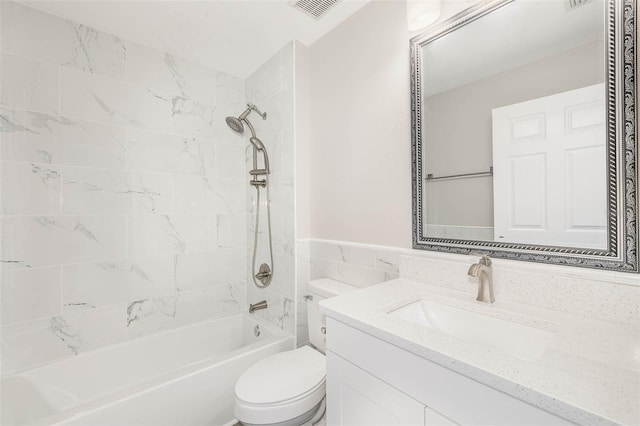 full bathroom with tiled shower / bath combo, toilet, and vanity