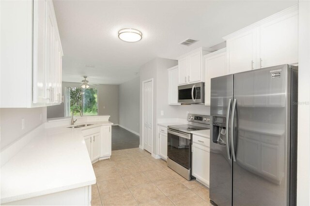 kitchen featuring visible vents, appliances with stainless steel finishes, light countertops, white cabinetry, and a sink