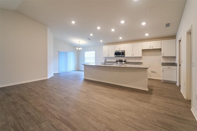 kitchen featuring sink, appliances with stainless steel finishes, hardwood / wood-style flooring, a center island with sink, and lofted ceiling