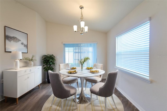 dining room featuring lofted ceiling, a chandelier, and dark hardwood / wood-style flooring