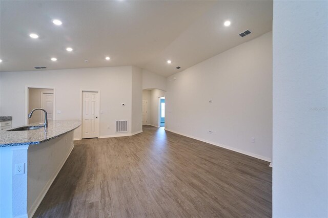 unfurnished living room featuring sink, lofted ceiling, and dark hardwood / wood-style floors