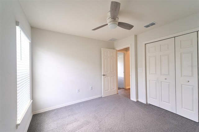 unfurnished bedroom featuring ceiling fan, a closet, and carpet