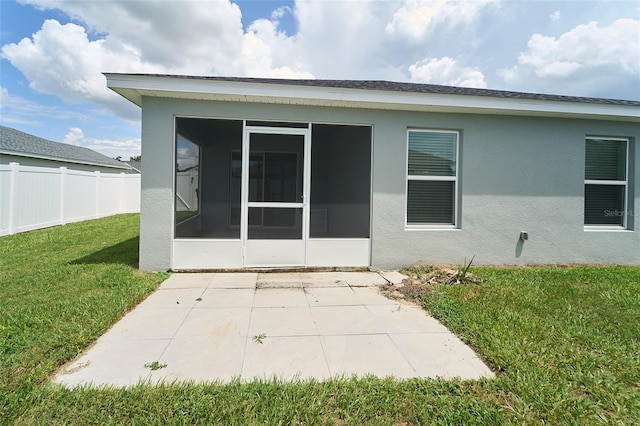 back of property featuring a sunroom and a yard