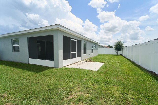 back of house with a sunroom and a lawn