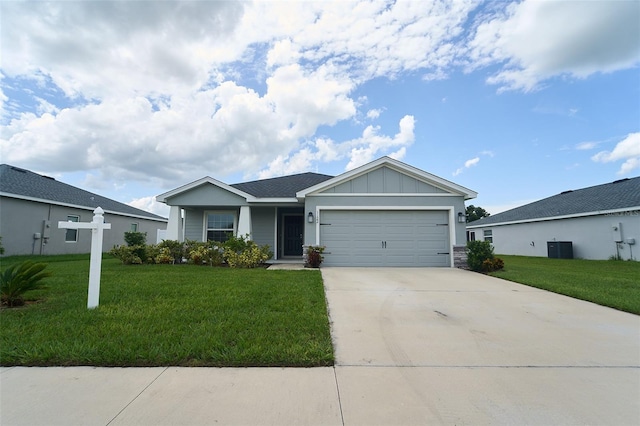 ranch-style home featuring central air condition unit, a front yard, and a garage