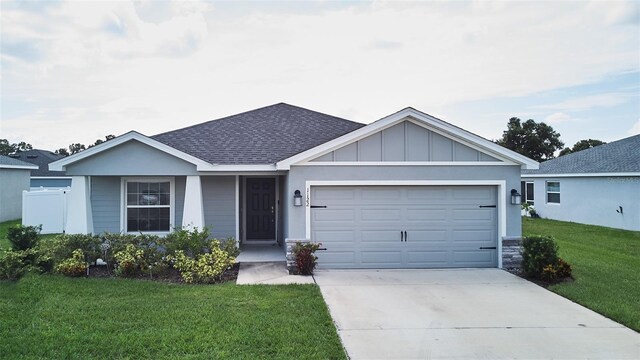 single story home featuring a garage and a front lawn