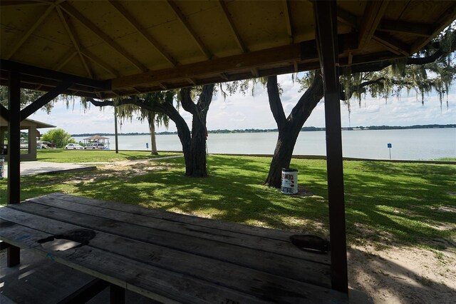 wooden deck with a gazebo, a yard, and a water view