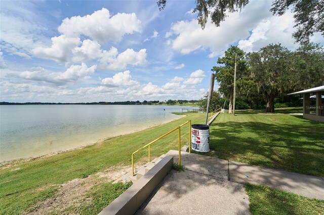 view of home's community with a lawn and a water view