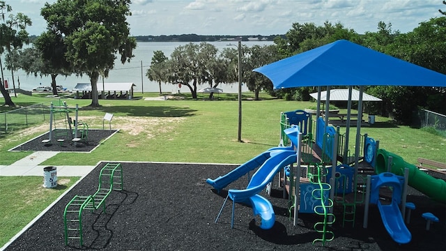 view of playground featuring a yard and a water view