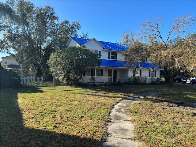 farmhouse-style home with covered porch and a front lawn