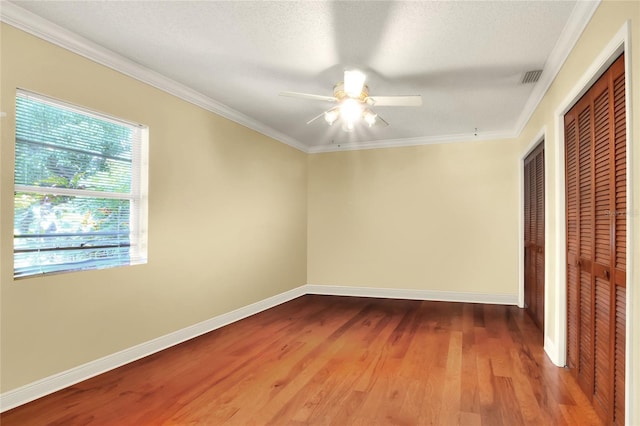 empty room featuring crown molding, hardwood / wood-style floors, a textured ceiling, and ceiling fan