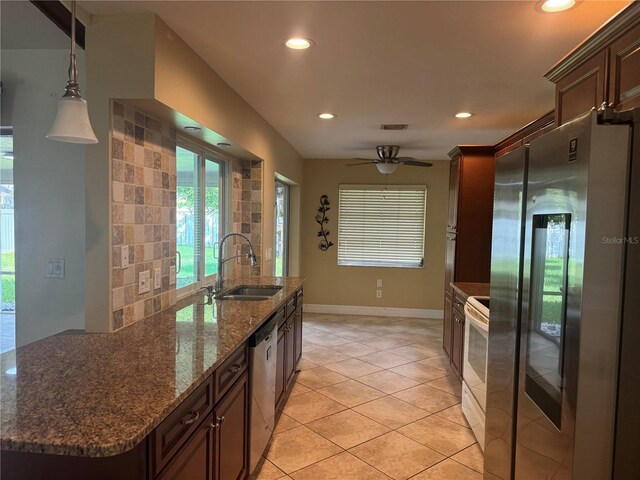 kitchen with backsplash, sink, hanging light fixtures, ceiling fan, and stainless steel appliances