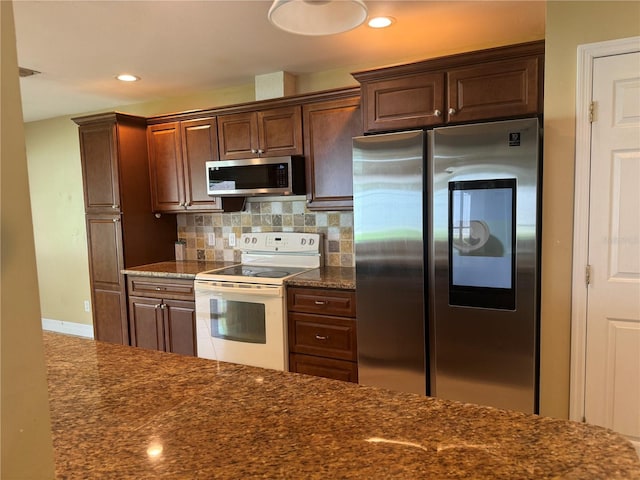 kitchen with dark brown cabinetry, tasteful backsplash, dark stone countertops, stainless steel appliances, and recessed lighting