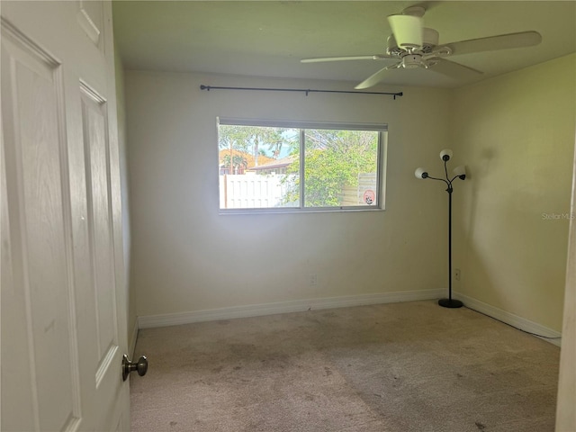 carpeted spare room featuring ceiling fan