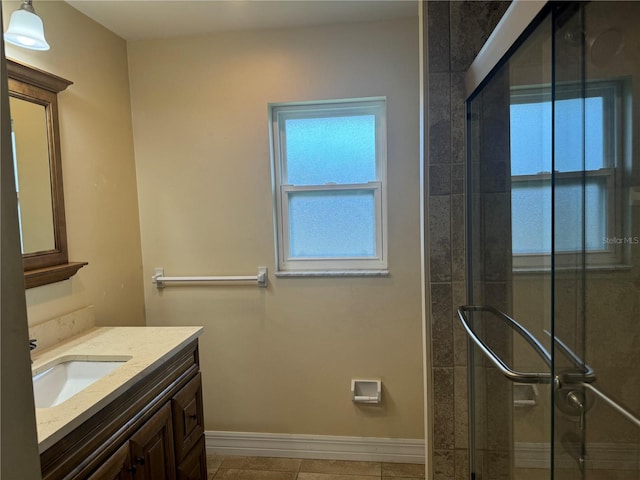 bathroom with an enclosed shower, vanity, and tile patterned floors