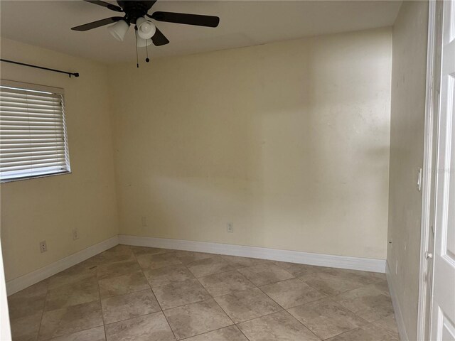 empty room with ceiling fan and light tile patterned floors