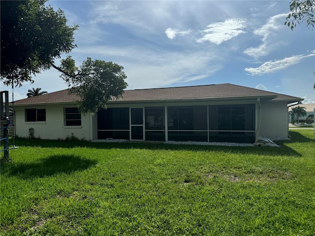 back of property featuring a yard and a sunroom