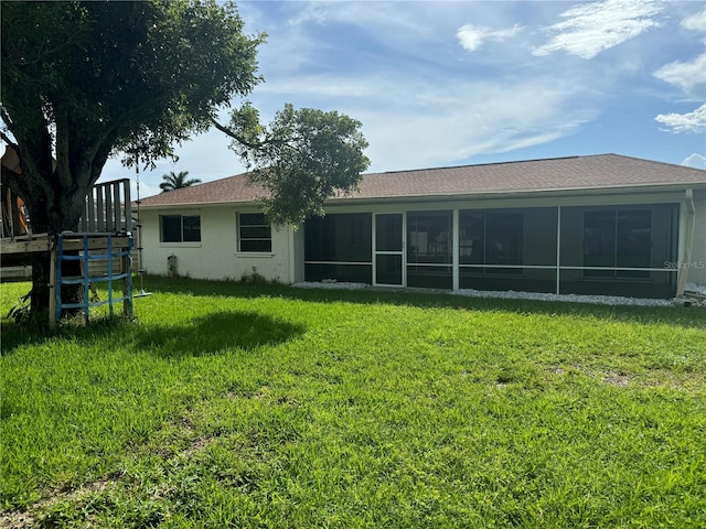 rear view of property featuring a yard and a sunroom