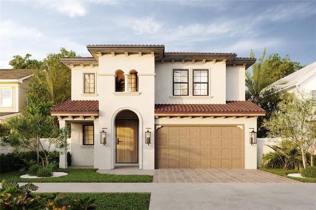 mediterranean / spanish home featuring a garage, a tile roof, decorative driveway, and stucco siding