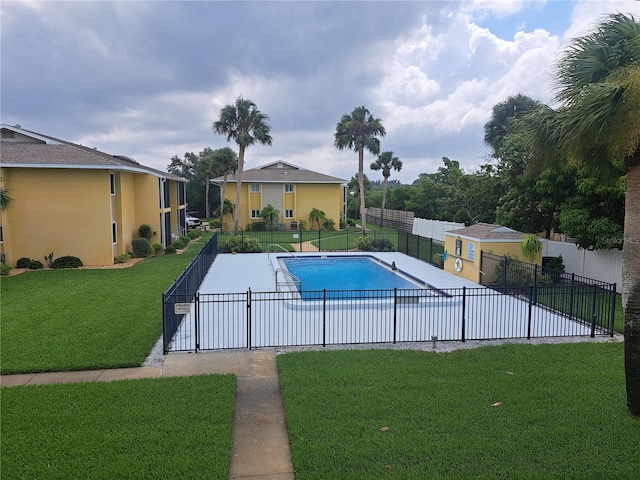 view of swimming pool with a lawn