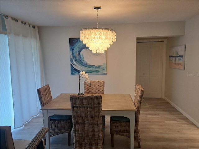 dining room with a chandelier and light wood-type flooring