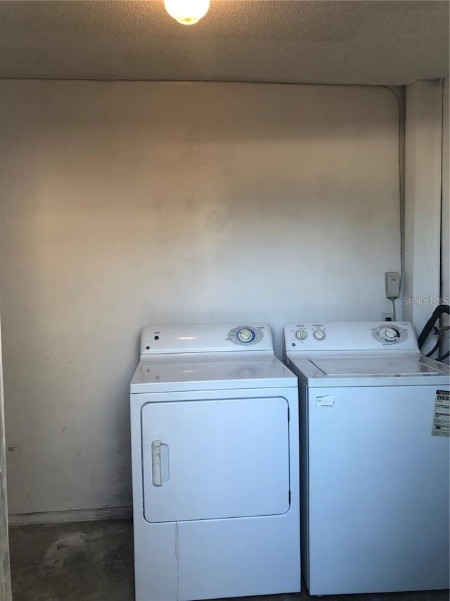 laundry room featuring separate washer and dryer and a textured ceiling