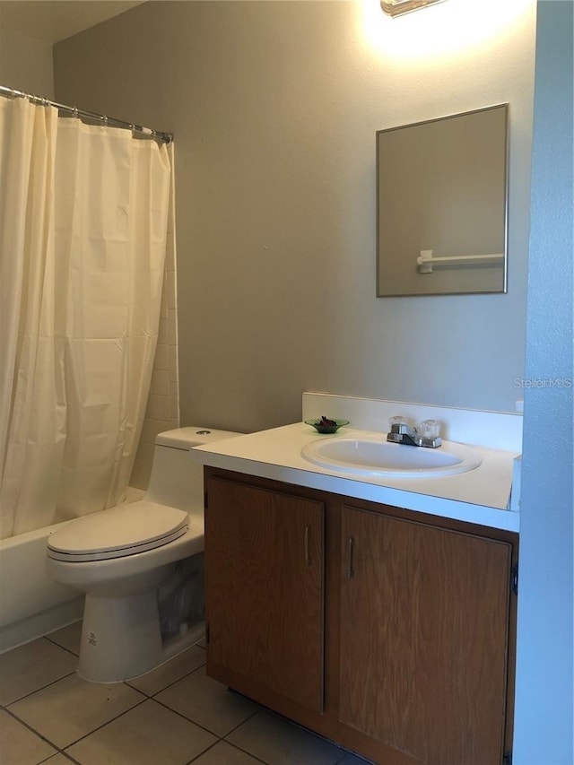 full bathroom featuring tile patterned flooring, toilet, vanity, and shower / bath combo with shower curtain