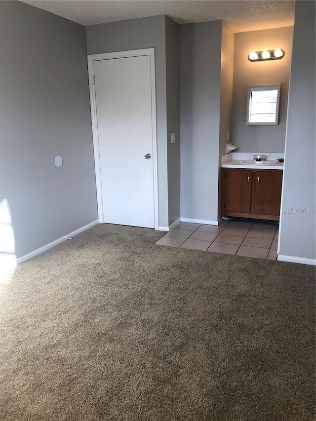 interior space featuring sink, connected bathroom, and light carpet