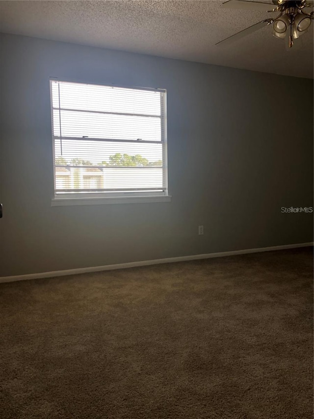 carpeted spare room featuring ceiling fan and a textured ceiling