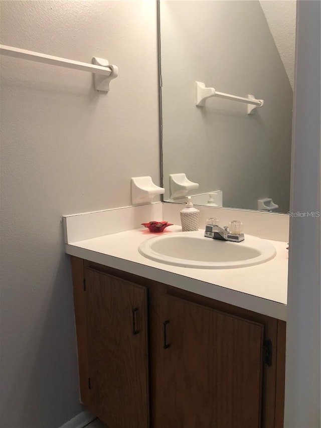 bathroom featuring lofted ceiling and vanity