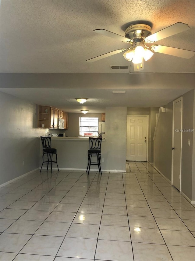 tiled spare room featuring ceiling fan