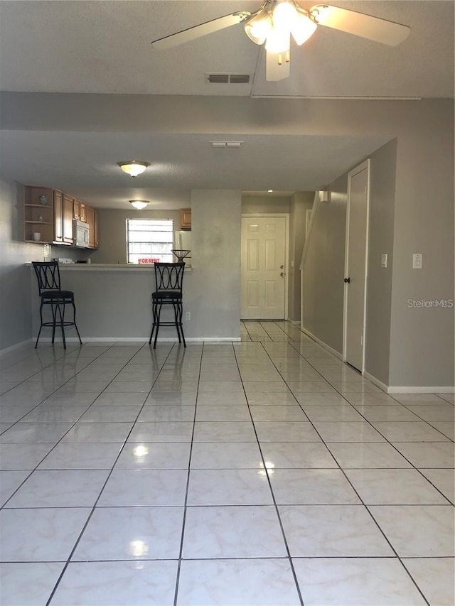 tiled empty room with ceiling fan