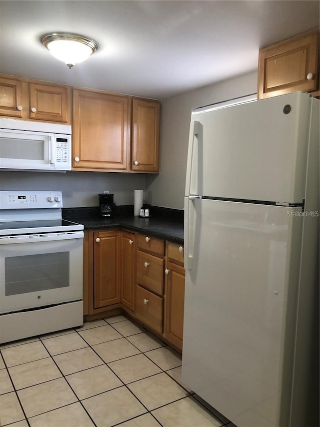 kitchen with white appliances and light tile patterned floors