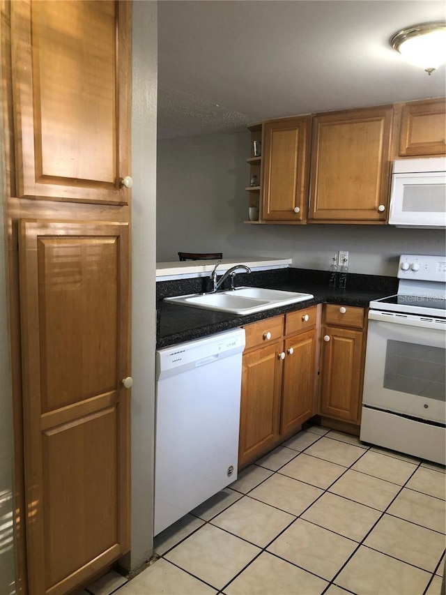 kitchen with sink, light tile patterned flooring, and white appliances