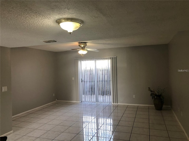 tiled spare room with ceiling fan and a textured ceiling