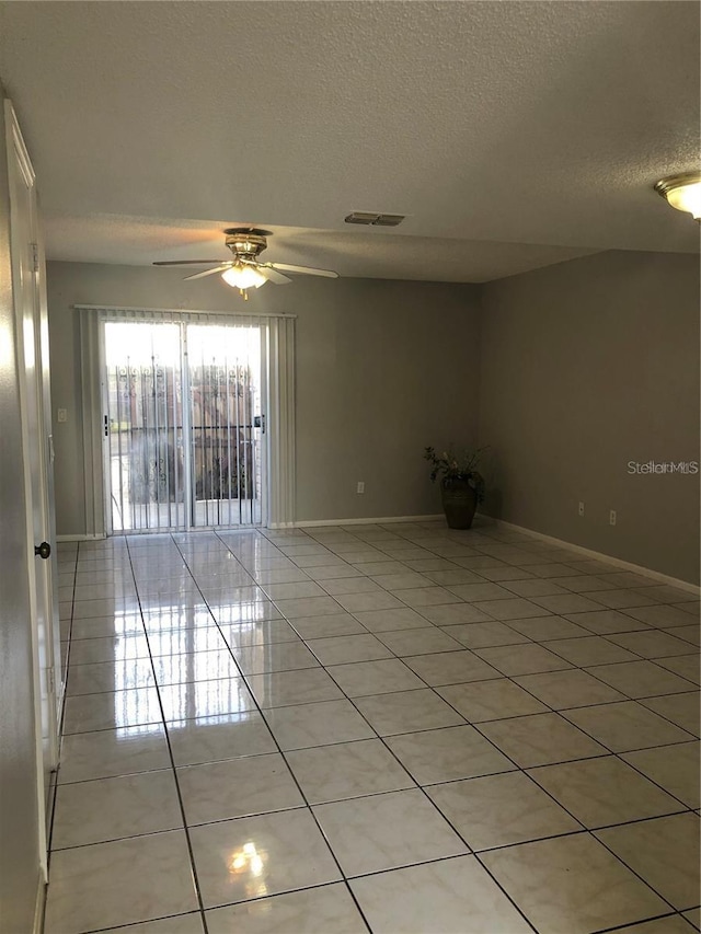 tiled spare room featuring ceiling fan and a textured ceiling