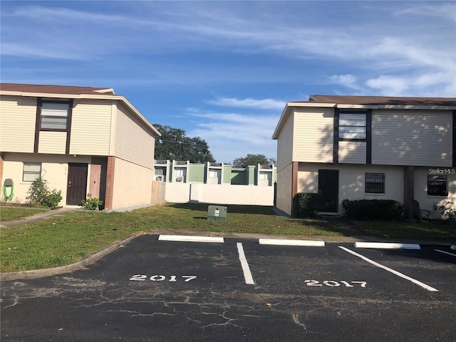 view of parking / parking lot featuring a lawn