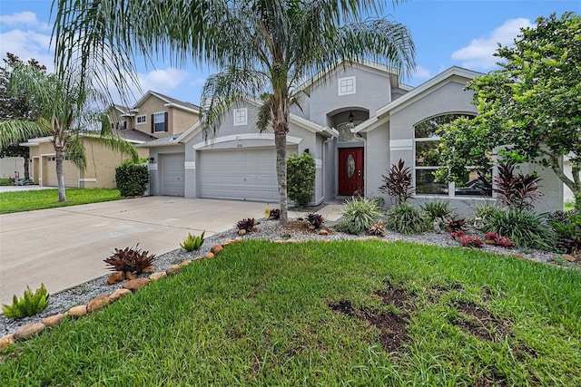 mediterranean / spanish house featuring a garage, a front yard, driveway, and stucco siding