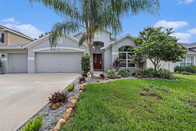 view of front of property featuring a front lawn, driveway, an attached garage, and stucco siding