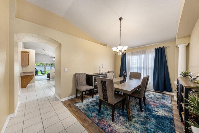 dining area with light hardwood / wood-style flooring, ceiling fan with notable chandelier, and vaulted ceiling