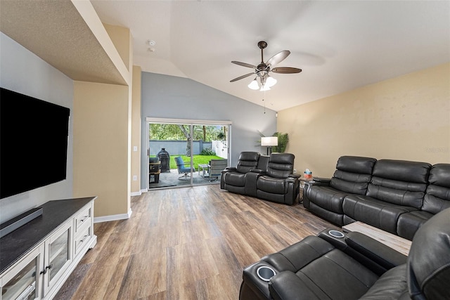 living area with lofted ceiling, baseboards, a ceiling fan, and wood finished floors