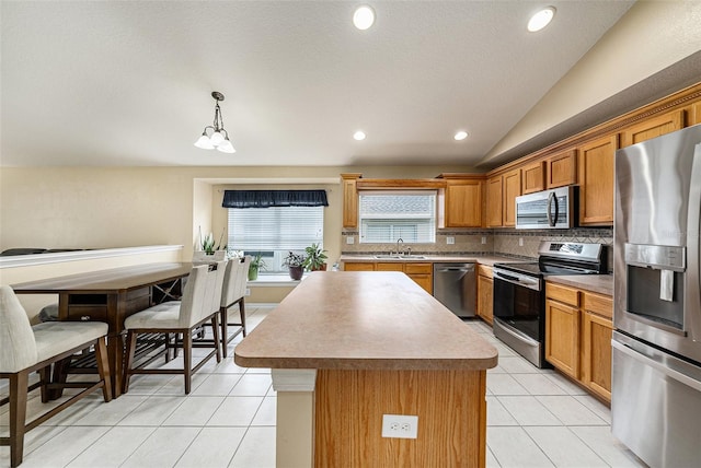 kitchen with sink, a center island, hanging light fixtures, tasteful backsplash, and appliances with stainless steel finishes