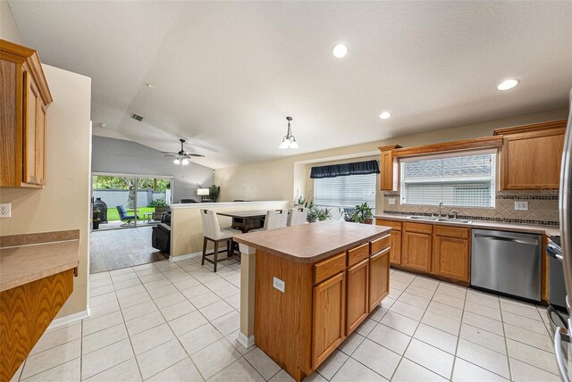 kitchen featuring sink, pendant lighting, dishwasher, a center island, and lofted ceiling