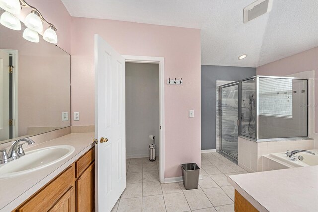 bathroom with tile patterned flooring, vanity, independent shower and bath, and a textured ceiling