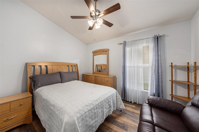 bedroom featuring dark wood-style floors, vaulted ceiling, and ceiling fan