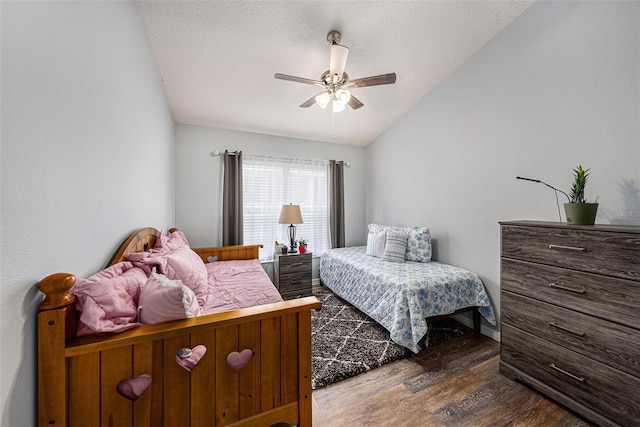 bedroom with a ceiling fan, dark wood-style flooring, vaulted ceiling, and a textured ceiling