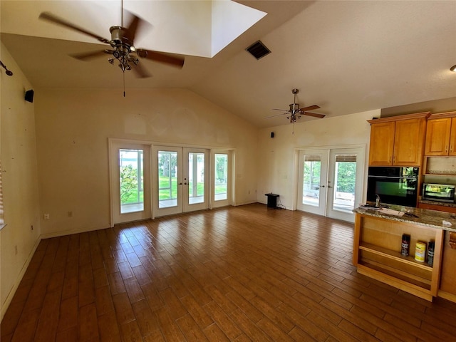 kitchen featuring black oven, french doors, light stone countertops, dark hardwood / wood-style flooring, and ceiling fan